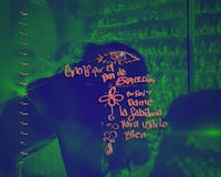 a person is standing in front of a green screen with writing on it